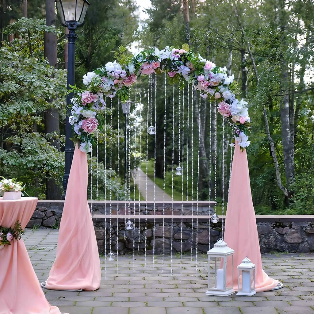Arche de mariage dorée : arche fleurie avec voilage rose.