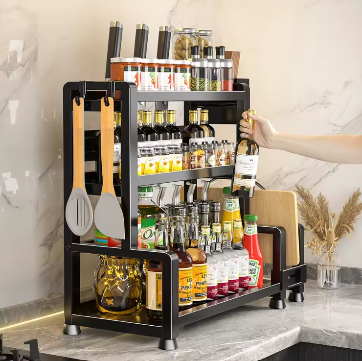 Organisateur de cuisine 3 niveaux en acier noir avec bouteilles, bocaux et ustensiles suspendus.