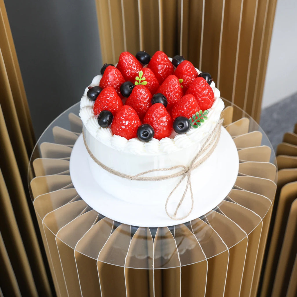 Colonnes de réception pliantes : gâteau présenté sur colonne dorée.