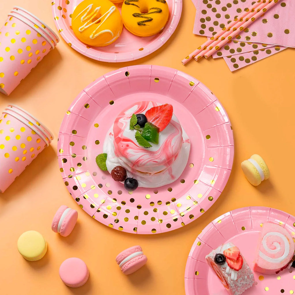 Vaisselle de fête rose et dorée à pois : détail d’une assiette avec dessert.