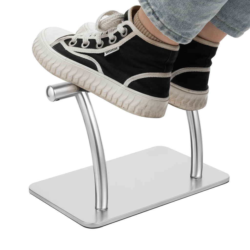 Repose-pieds de bureau en acier inoxydable argenté — pieds posés sur la barre
