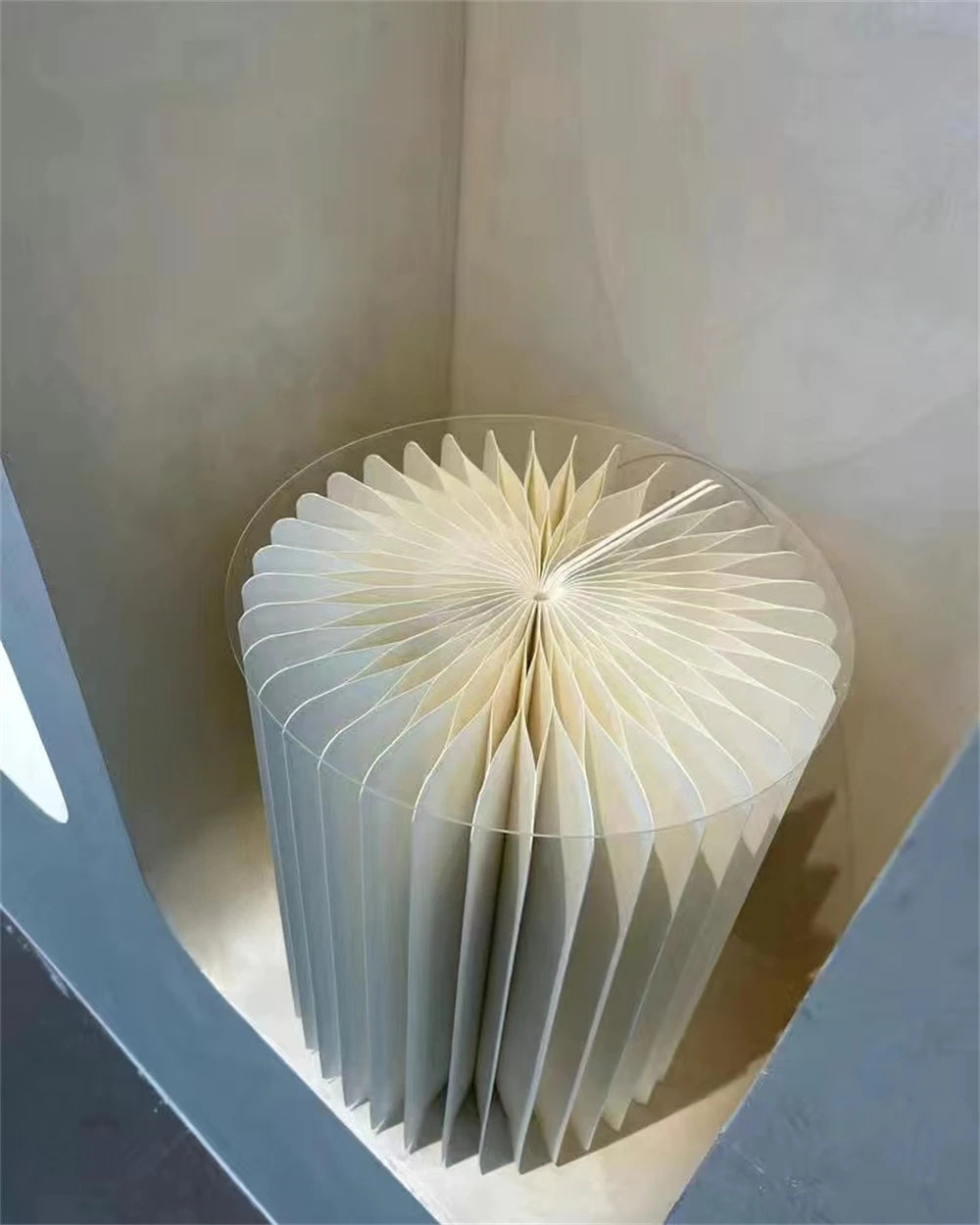 Colonne décorative pliante en papier blanc : vue du dessus du papier plissé.