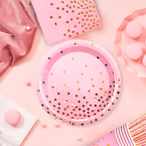 Vaisselle de fête rose et dorée à pois : gros plan des assiettes roses à pois dorés.
