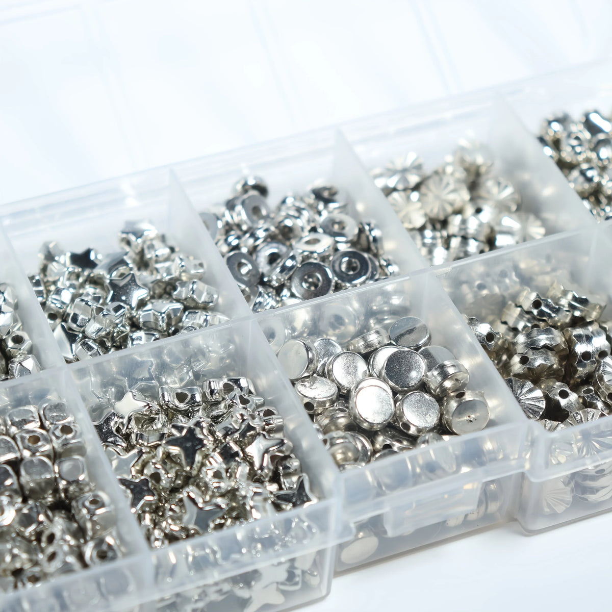 Gros plan de perles DIY argentées dans des compartiments, pour création de bijoux