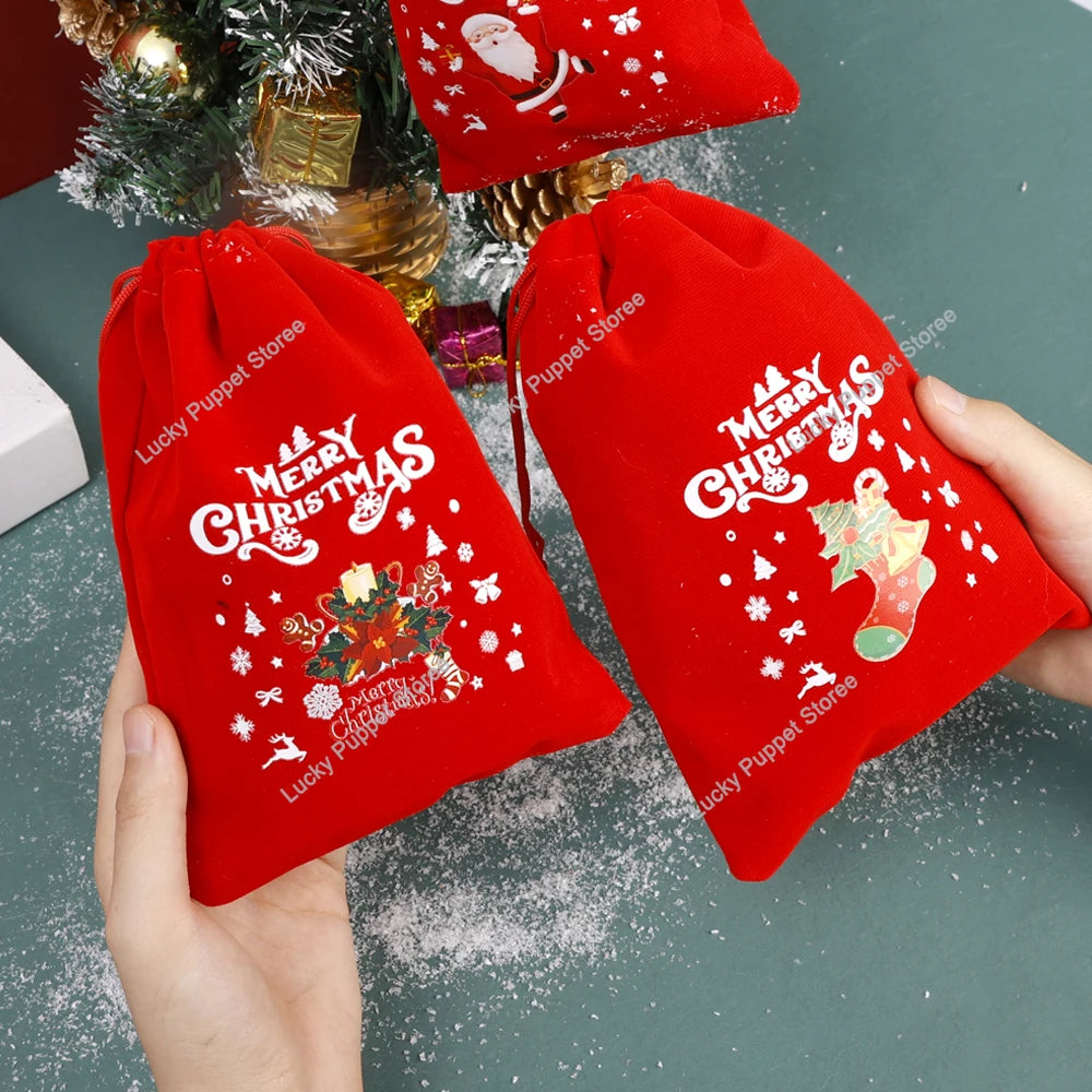 Deux pochettes cadeaux de Noël rouges à cordon présentées à la main
