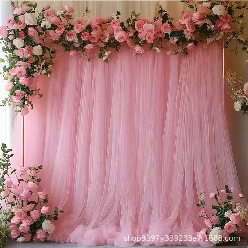 Fond d’arche en tulle rose clair, rideaux à plis fluides pour décoration de mariage.