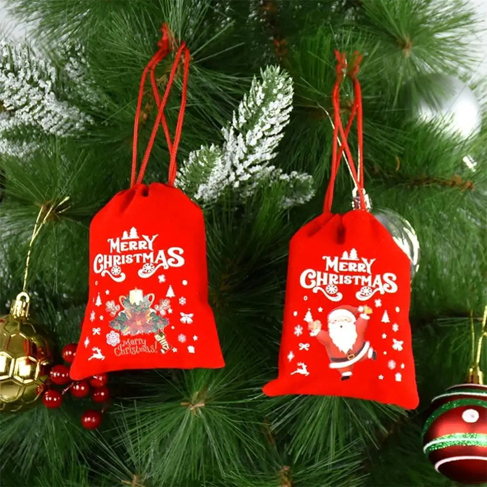 Sacs cadeaux de Noël rouges sur une branche de sapin
