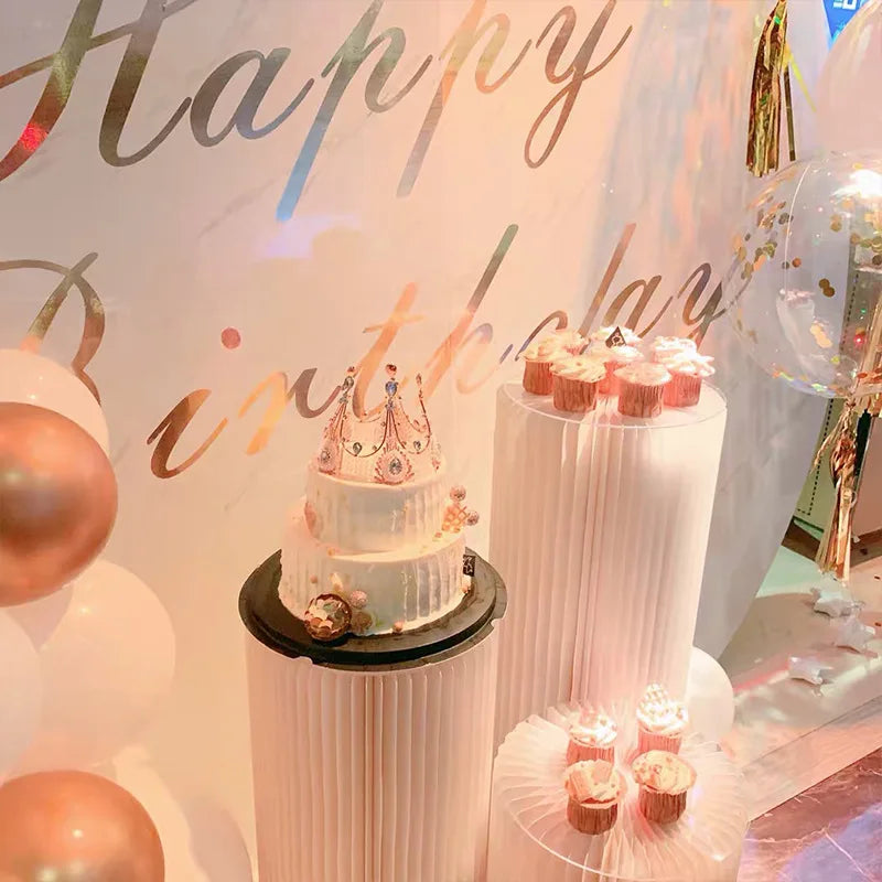 Colonne décorative pliante en papier blanc : colonnes et gâteaux dans une ambiance rose.