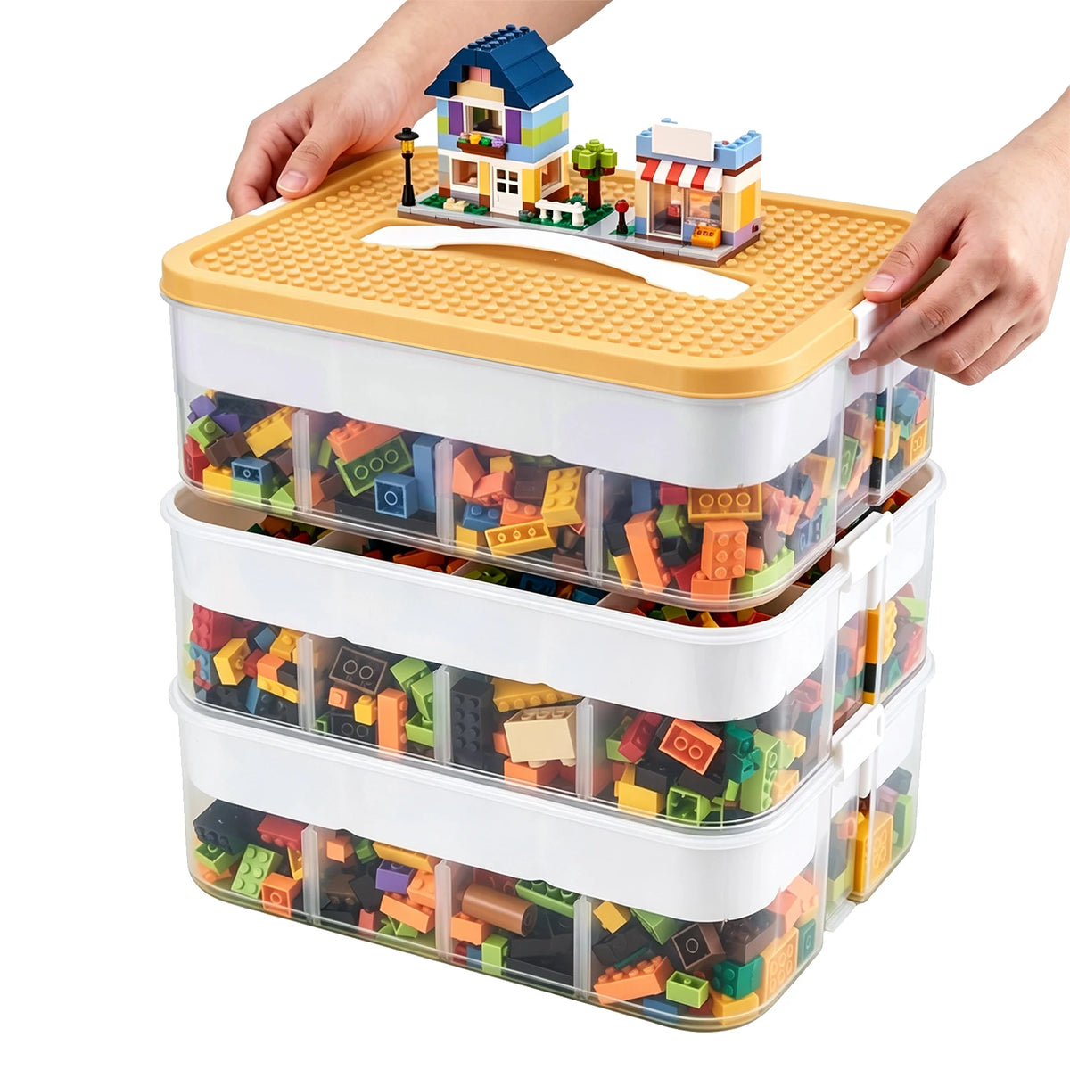 Boîte de rangement plastique à 3 niveaux, couvercle orange, blocs de construction à l’intérieur.