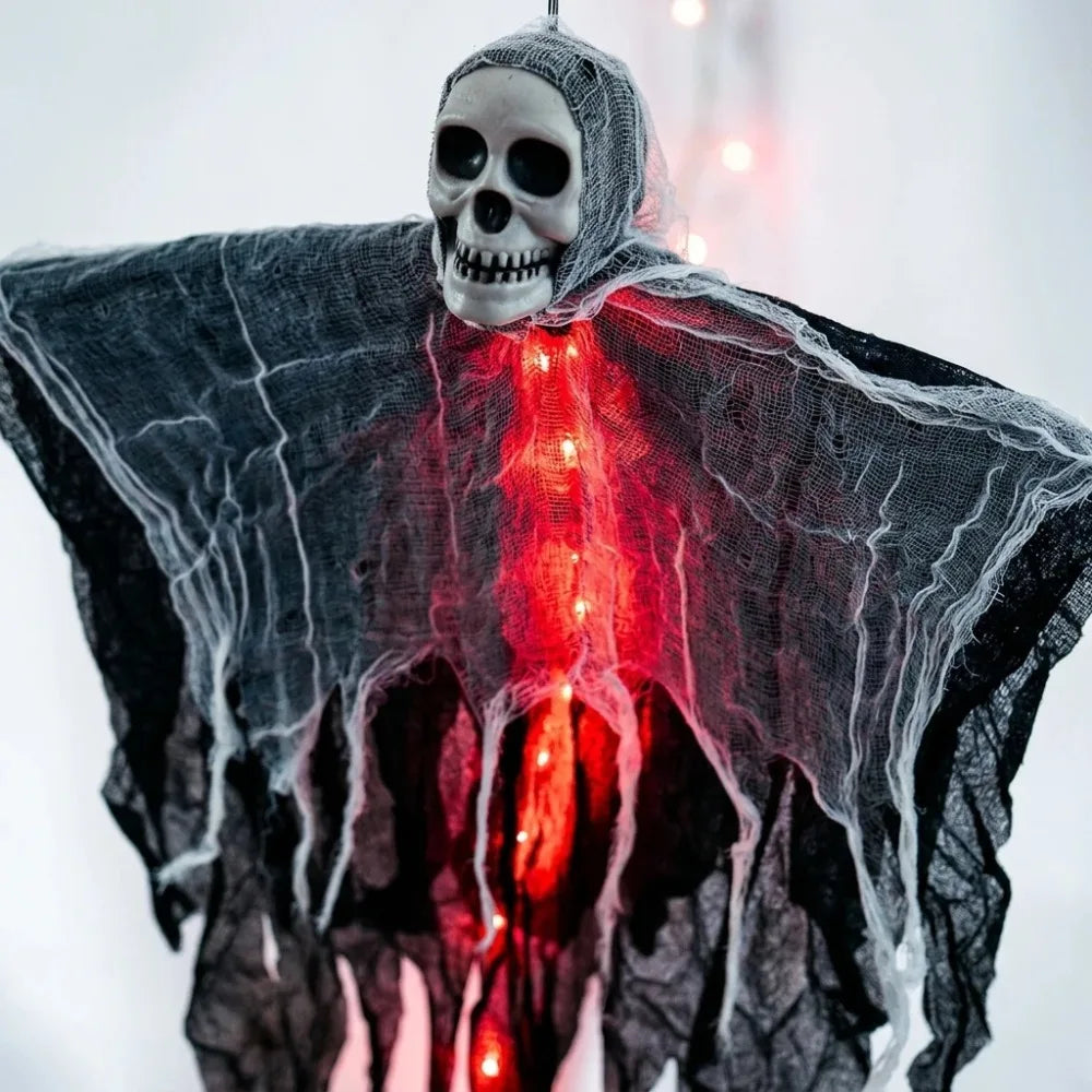 Squelette fantôme lumineux à suspendre pour Halloween : détail de la gaze et des lumières rouges.