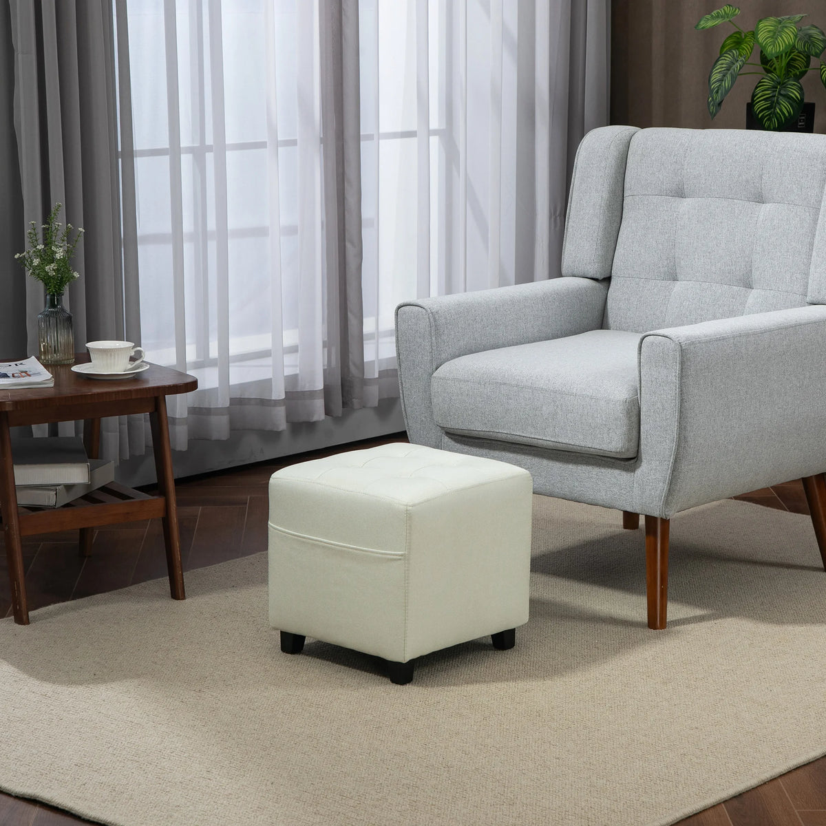 Pouf repose-pieds crème avec poche latérale, 35 cm — près d’un fauteuil
