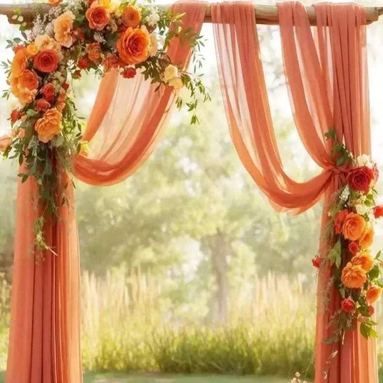 Rideaux en tulle orange et drapés vaporeux, avec nœuds et finitions pour arche décorative.