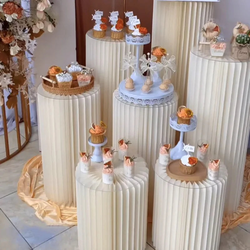 Colonne décorative pliante en papier blanc : présentation de desserts à plusieurs hauteurs.