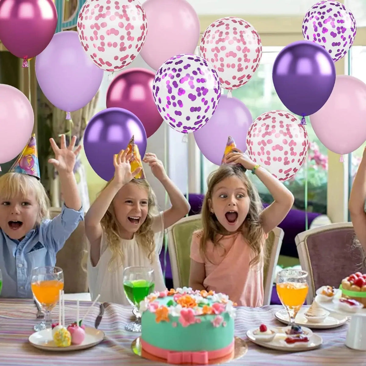 Bouquet de ballons roses et violets près d’un gâteau