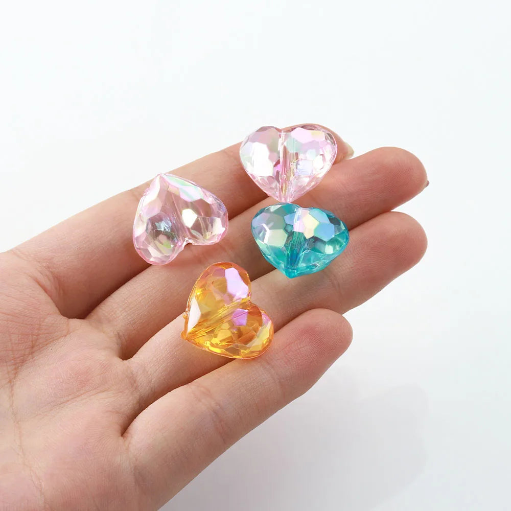 Perles cœur multicolores présentées dans une main